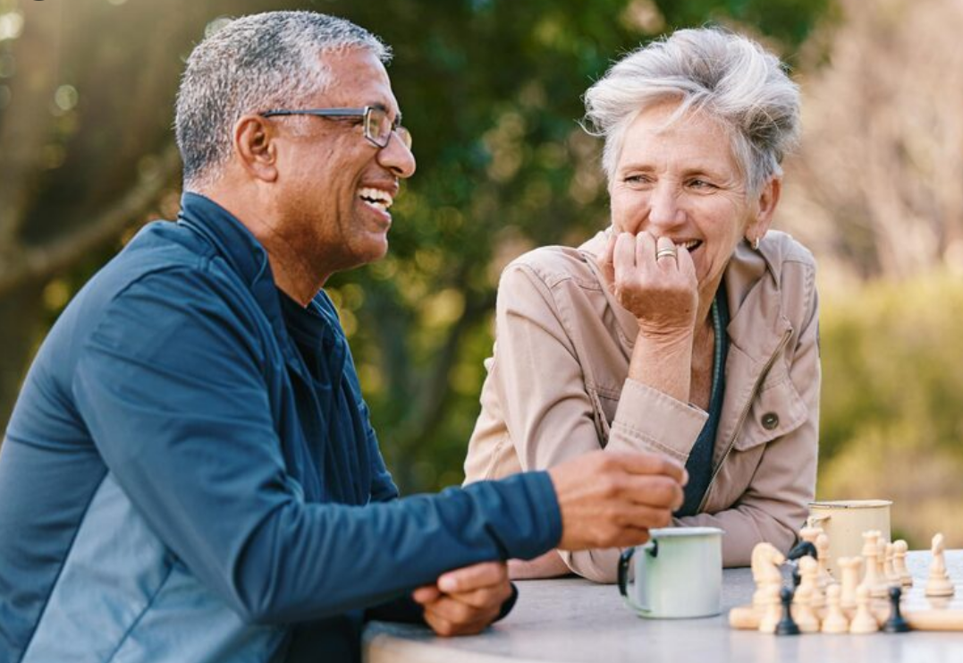Mature couple talking outdoors over coffee